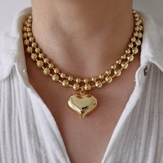 This eye-catching statement necklace has a large puffy heart pendant on a thick gold filled ball chain. The whole piece is made of 18K gold filled brass, which looks almost like 18K solid gold. You can mix and match this necklace with your other gold or gold plated necklaces for a chic look.  This necklace can be sold separately or as a set with another 6 mm plain ball chain. The two chains complement each other and create a layered effect. The set is also available for purchase. MATERIALS: - 18 Bold Necklace Statement Jewelry, Preppy Necklaces, Gold Ball Chain, Preppy Accessories, Chunky Gold Necklaces, Choker Necklace Gold, Heart Choker Necklace, Preppy Jewelry, Charm Choker Necklace