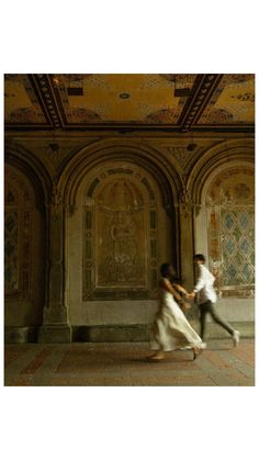 two people are dancing in an old building