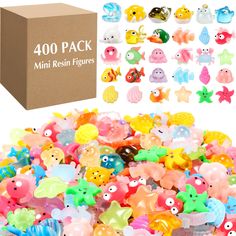 a box filled with lots of different colored plastic toy fish next to it's packaging