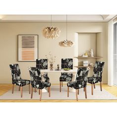 a dining room table with black and white chairs