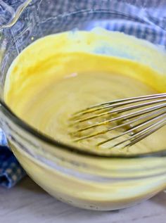 a glass bowl filled with batter and whisk