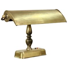 an antique brass desk lamp on a white background