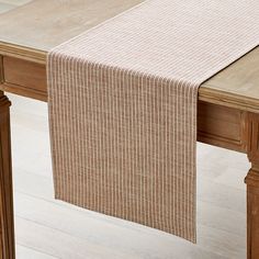 a wooden table topped with a white and brown table runner