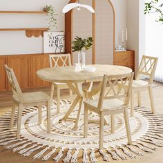 a dining room table with four chairs and a rug on the floor in front of it