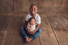 two children are sitting on the floor and smiling