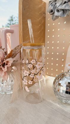 a glass vase with flowers in it sitting on a table