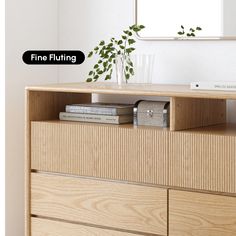 a wooden dresser with books and a vase on top that says fine fluffining