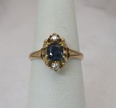 a close up of a ring with a blue stone in it on a white surface