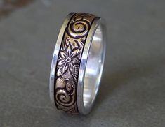 a wedding ring with an intricate design on the outside and inside, sitting on a surface