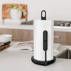 a black and white paper towel holder on a kitchen counter