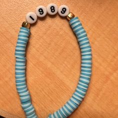 a blue and white beaded bracelet with numbers on the end is sitting on a table