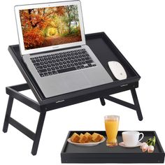 a laptop computer sitting on top of a tray next to a plate of food and drink