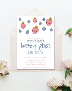 a birthday card with strawberries and blueberries on it, sitting next to flowers