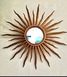 a sun shaped mirror mounted to the side of a wall next to a white wall