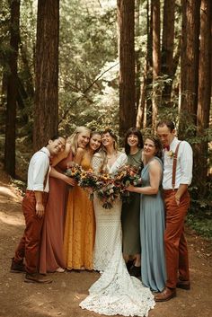 a group of people standing next to each other in the woods