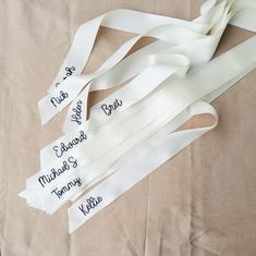 white ribbons with names on them laying on a bed