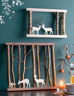 two wooden shelves with deer cutouts on them and candles in the foreground, against a teal wall