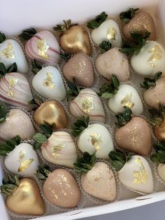 a box filled with chocolate covered strawberries and gold leafy decorations on top of them