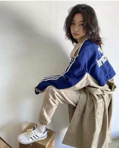 a woman sitting on top of a wooden box