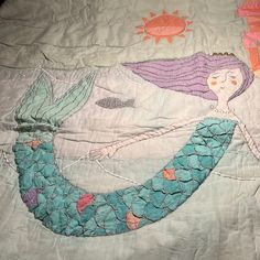 an image of a mermaid quilt on a bed