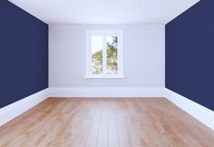 an empty room with blue walls and wooden floors