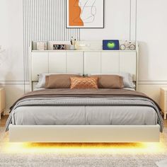 a bedroom with white walls and wooden flooring, an upholstered bed frame is illuminated by yellow leds