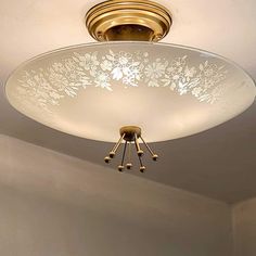 a ceiling light with an etched glass bowl on the bottom and two lights above it