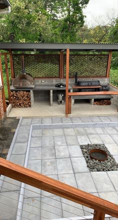 an outdoor kitchen with grill, sink and table