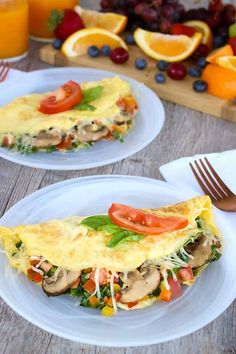 two white plates topped with omelets and vegetables