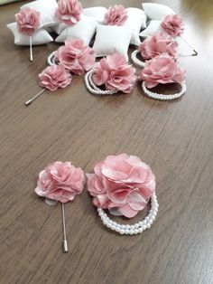 some pink flowers and pins on a table