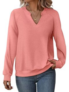 a woman wearing a pink sweater and jeans