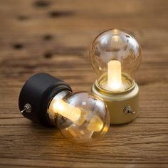 two light bulbs sitting on top of a wooden table