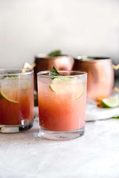 two glasses filled with watermelon and limeade on top of a white table