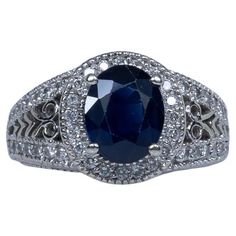 an oval shaped blue sapphire and diamond ring with filigrees around the band