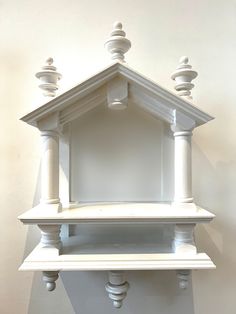 a white clock on the wall with columns