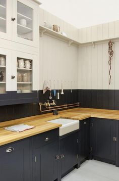 a kitchen with black and white walls, wooden counter tops and an advertisement for austerity chic