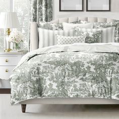 a bed with green and white comforters in a bedroom