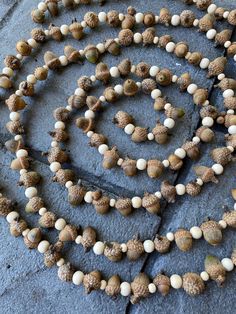 a long beaded necklace with white and brown beads on it's end is laying on the ground