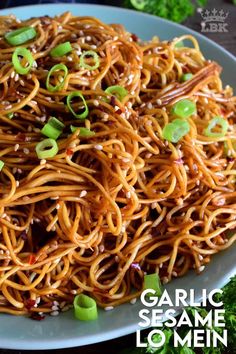 a white plate topped with noodles covered in sesame seeds