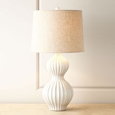 a white lamp sitting on top of a table