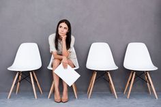 a woman sitting in front of three white chairs with the caption, the dangers of sitting