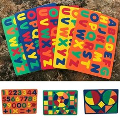 four colorful stickers with numbers and symbols on them next to each other in front of a rock