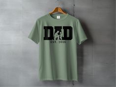 Celebrate fatherhood with this personalized Dad T-Shirt featuring "Dad Established 2016". A perfect custom Father's Day gift, this shirt makes a wonderful present for new dads and established fathers alike. Customize the year to mark the memorable moment of becoming a dad. This unique tee is not only stylish but also meaningful, making it the ideal gift to show appreciation for dad on Father's Day or any special occasion. Product Features: Fabrication: Medium fabric (6.1 oz/yd² (206.8 g/m. Garment-dyed fabric. 100% ring-spun cotton Fit: Relaxed fit Sizing: Unisex Sizing Label: Sewn-in twill label Soccer Dad Shirt, Soccer Design, Customizable Shirts, Papa Shirts, Gifts For New Dads, Dad Birthday Gift, New Dads, Dad Birthday, Dyed Fabric