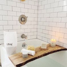 a bathtub with soap, popcorn and candles on the counter in front of it