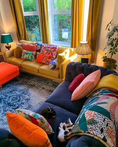 a living room filled with lots of furniture and colorful pillows on top of it's couches