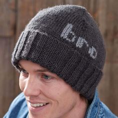 a young man wearing a knitted hat with the word love written on it and smiling