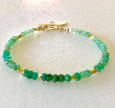 "Lovely natural green chrysoprase gemstone beaded bracelet with 24k gold vermeil accents. Beautiful Australian chrysoprase gems are 4mm faceted rondelles in luscious shades of light to darker apple green. 2mm faceted 24k solid gold vermeil cubes add sparkling accents. Made to order on professional beading wire with 14k gold fill spring ring clasp and findings. A little 22k gold vermeil leaf charm dangles from 1\" extension. Also available in .925 Sterling silver."