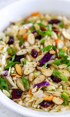 a white bowl filled with rice and veggies on top of a marble table