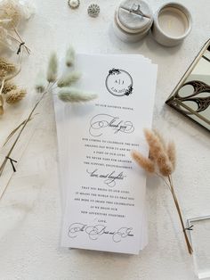 the wedding stationery is laid out on top of the table with feathers and candles