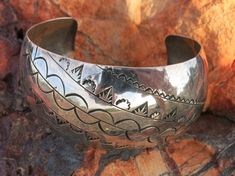 "WIDE NAVAJO BRACELET, Vinatge, Hand Stamped with Navajo Symbol Designs of Sunbursts, Arrows, Signed with the initial \" H\" on the inside also stamped \"Sterling\" Size 6 1/2\" inside circumference including a 1 3/8\" Gap. Slightly adjustable with care. 31 Grams 1 1/4\" Wide Pre-owned in very good condition. Some Patina, minor scratches and slightly out of round. Ships USPS 1st Class Mail" Bohemian Stamped Bracelets For Wedding, Bohemian Stamped Bracelet For Wedding, Southwestern Style Stamped Sterling Silver Bangle, Adjustable Etched Sterling Silver Southwestern Bracelet, Southwestern Engraved Silver Cuff Bracelet, Victor Moses, Southwest Jewelry Navajo Silver Cuff Bracelets, Jerry Garcia Band, Nickel-free Southwestern Sterling Silver Bracelet